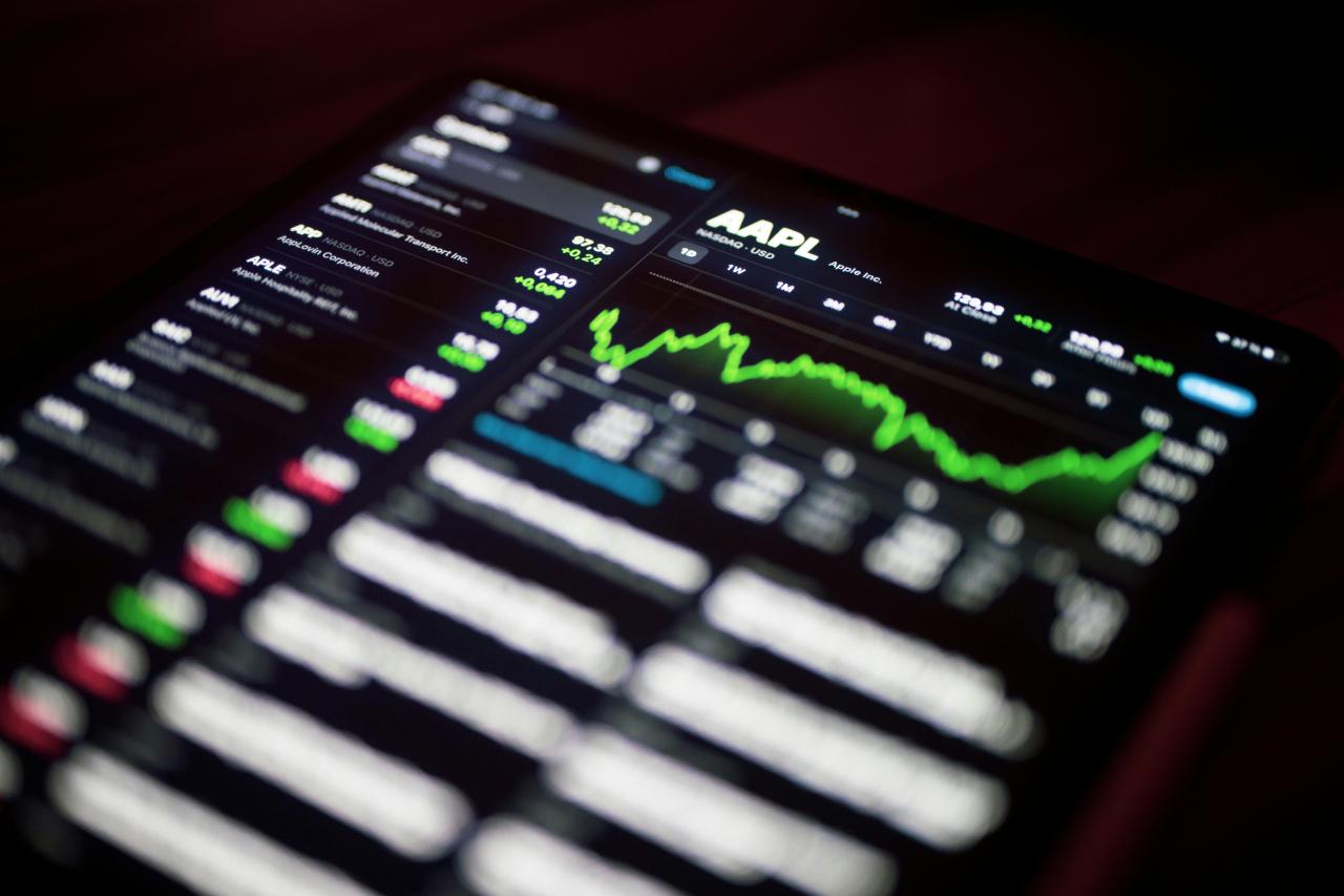 close-up ponsel dengan grafik saham di atasnya