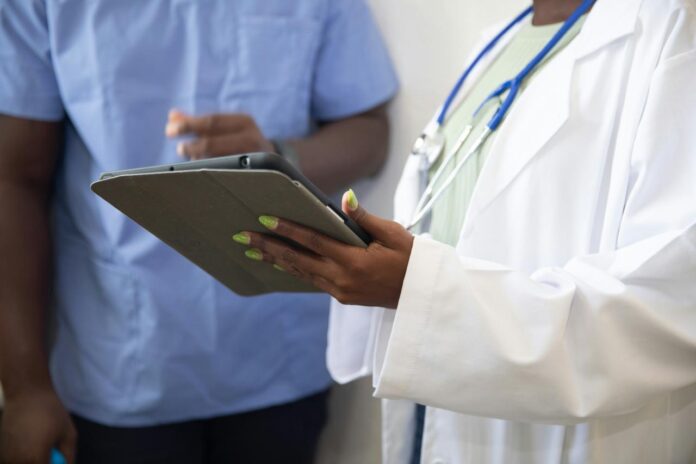 seorang dokter menunjukkan sesuatu kepada pasien di tablet