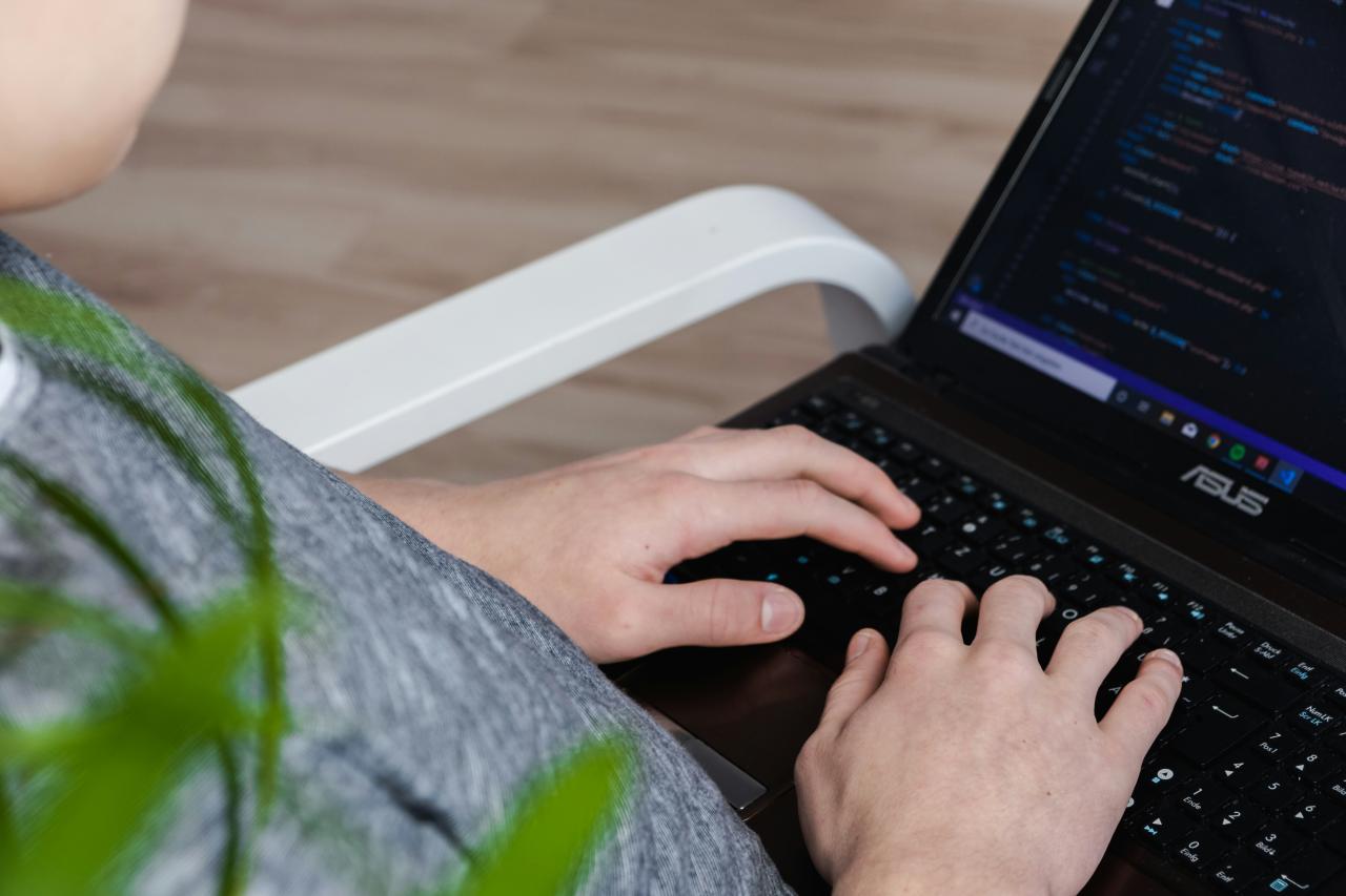orang yang menggunakan laptop Asus hitam
