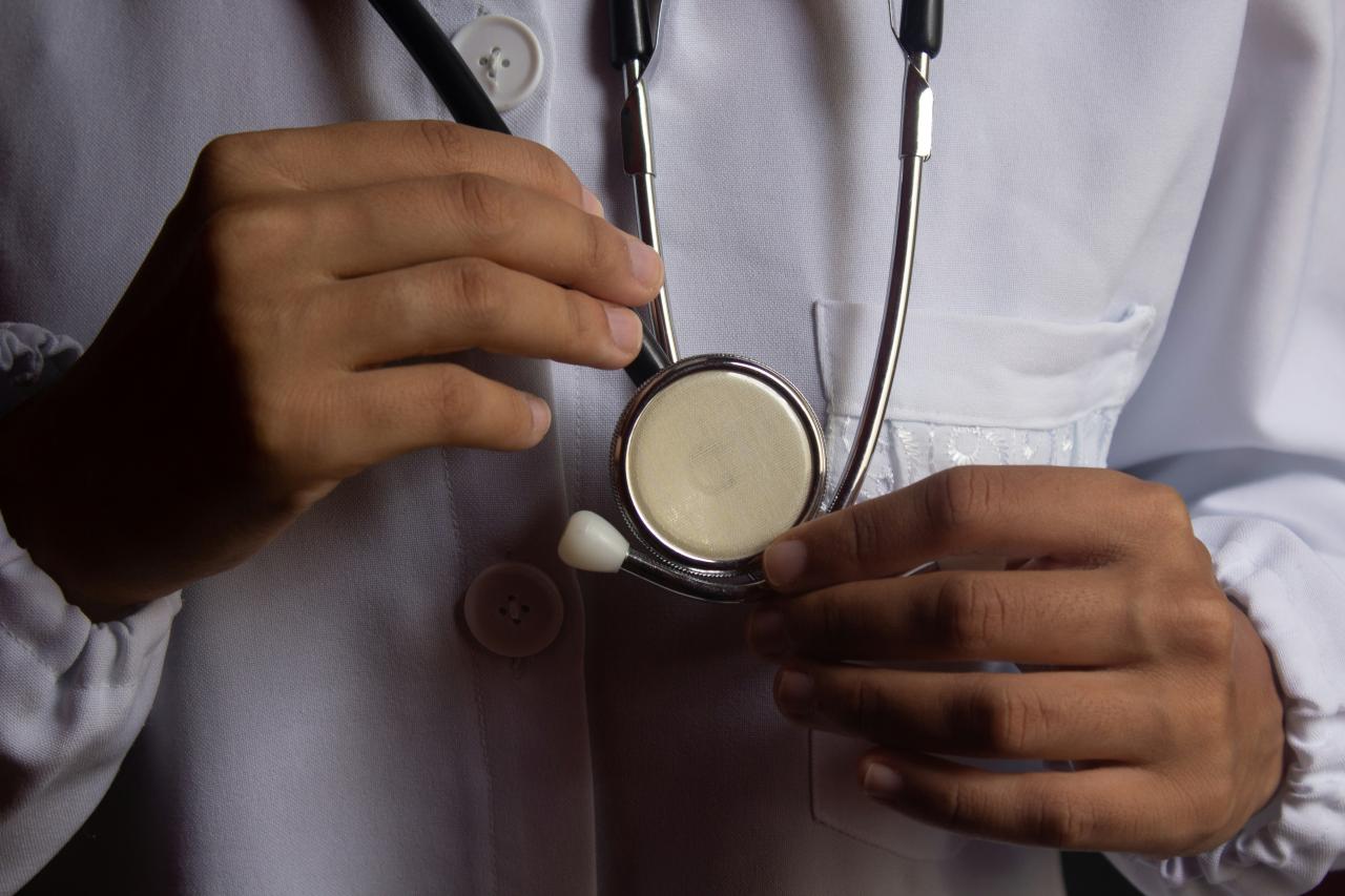 Seorang dokter memegang stetoskop di tangannya