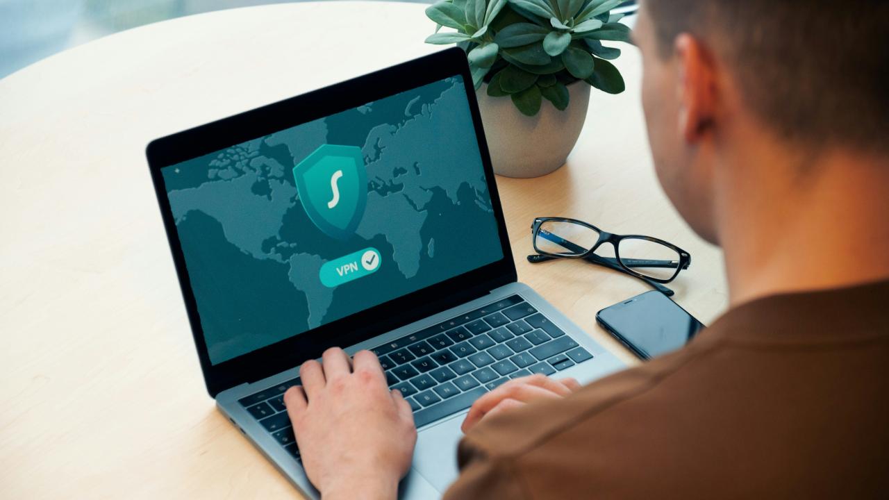 Orang yang menggunakan MacBook Pro di meja putih